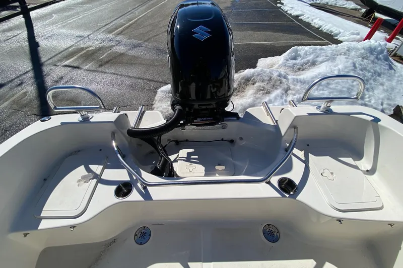 Slide: The Image of 2022 Pioneer 202 Sportfish boat with Suzuki outboard motor, parked on snowy pavement. - 11