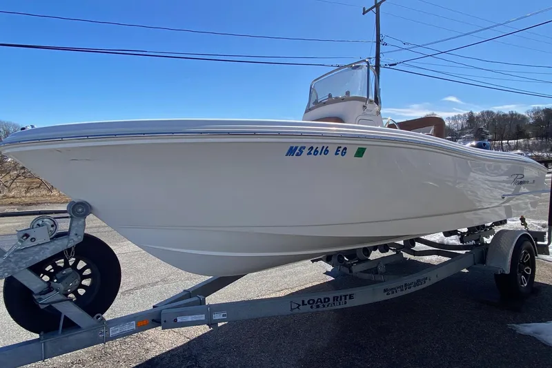 Slide: The Image of 2022 Pioneer 202 Sportfish boat on trailer, parked outdoors under clear blue sky. - 2