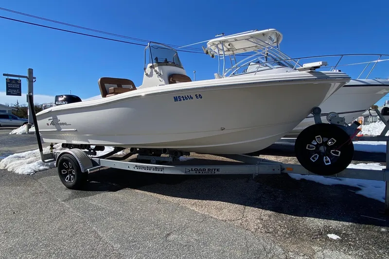 Slide: The Image of 2022 Pioneer 202 Sportfish boat on trailer, displayed outdoors under clear blue sky. - 6