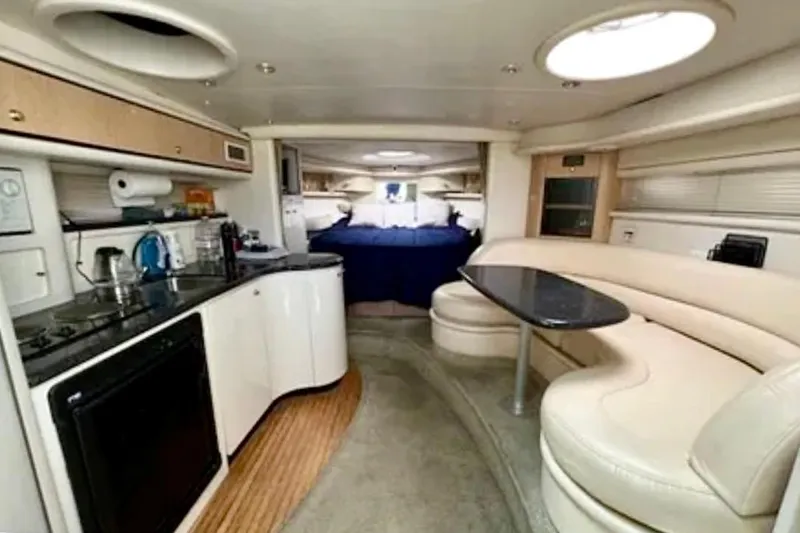 Slide: The Image of 2000 Maxum 3700 SCR yacht cruising on water with city skyline backdrop. - 4