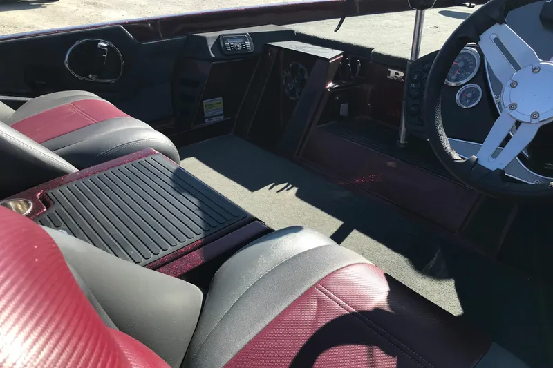 Slide: The Image of 2016 Ranger Z118 Comanche boat interior with maroon and gray seating, steering wheel, and dashboard. - 19