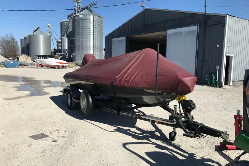Slide: The Image of 2016 Ranger Z118 Comanche boat covered on trailer near industrial buildings. - 28