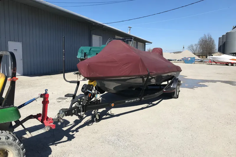 Slide: The Image of 2016 Ranger Z118 Comanche boat covered and hitched to a tractor in a parking area. - 29