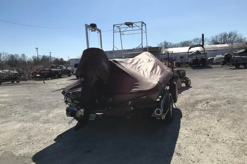 Slide: The Image of 2016 Ranger Z118 Comanche boat covered and parked outdoors in a lot. - 32