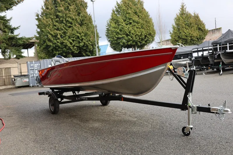 Slide: The Image of 2026 Lund 1600 Fury Tiller boat on trailer, parked outdoors. - 11