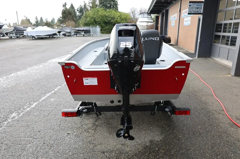 Slide: The Image of 2026 Lund 1600 Fury Tiller boat with Mercury 25 engine, parked outdoors. - 5