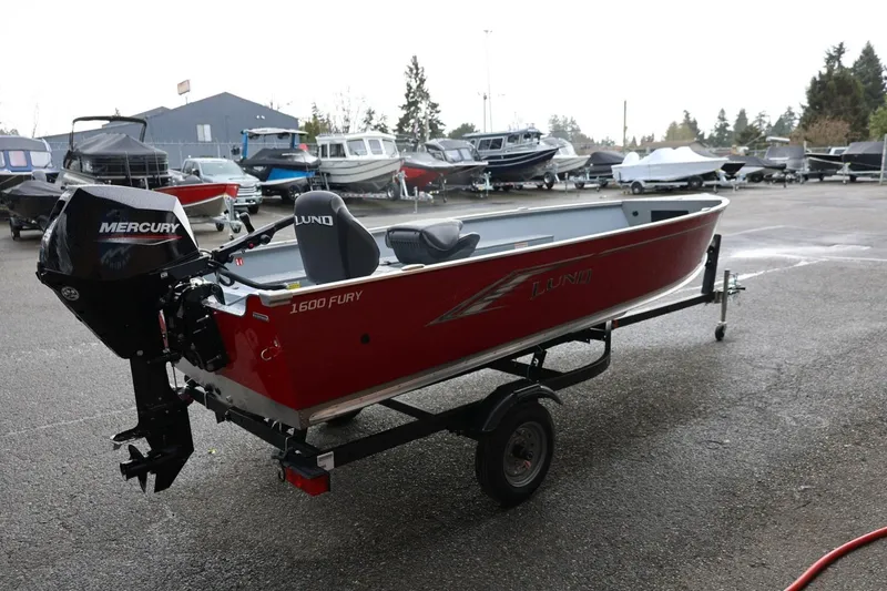 Slide: The Image of 2026 Lund 1600 Fury Tiller boat with Mercury engine on trailer in parking lot. - 8