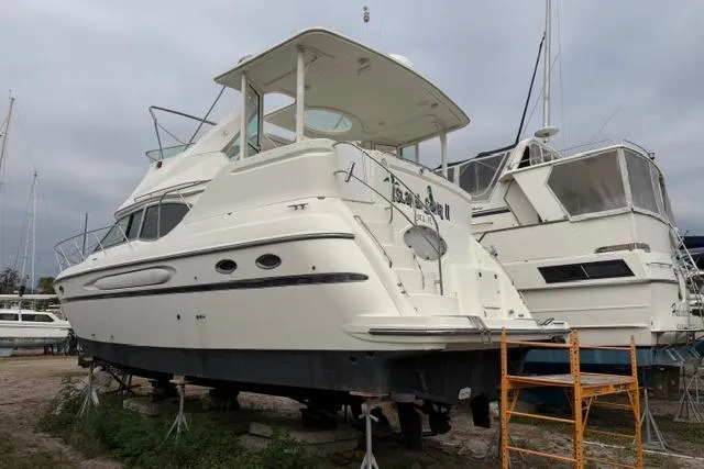 Slide: The Image of 2000 Maxum 4100 SCA yacht on dry dock, surrounded by other boats. - 11