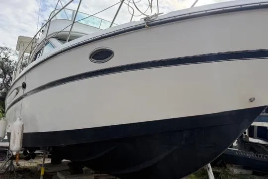 Slide: The Image of 2000 Maxum 4100 SCA yacht on dry dock, showcasing sleek design and sturdy hull. - 12