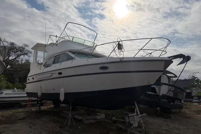 Slide: The Image of 2000 Maxum 4100 SCA yacht on dry dock under cloudy sky. - 16