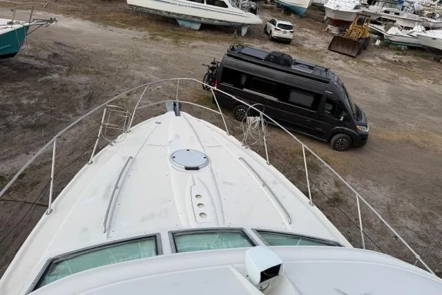 Slide: The Image of 2000 Maxum 4100 SCA yacht on land, with a black van nearby. - 18
