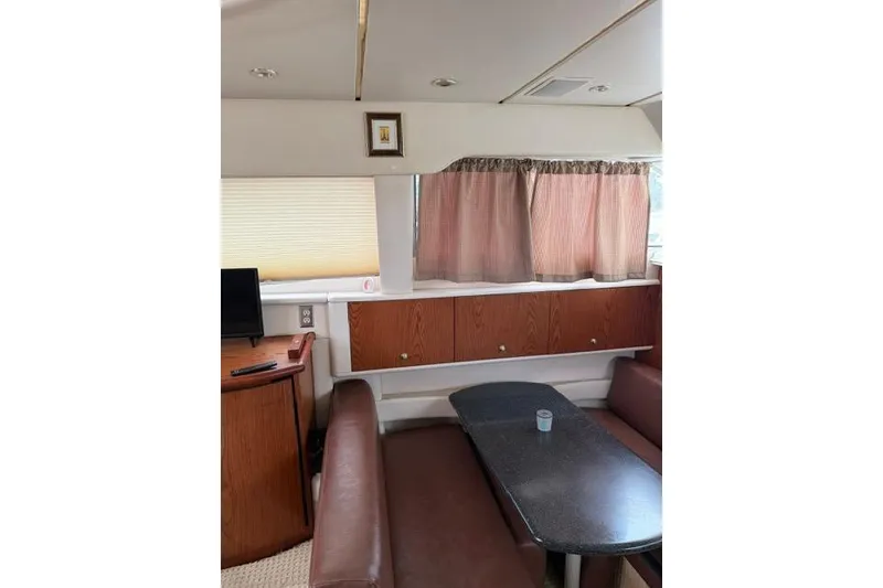 Slide: The Image of Interior of 2000 Maxum 4100 SCA yacht with dining area and wooden cabinetry. - 26