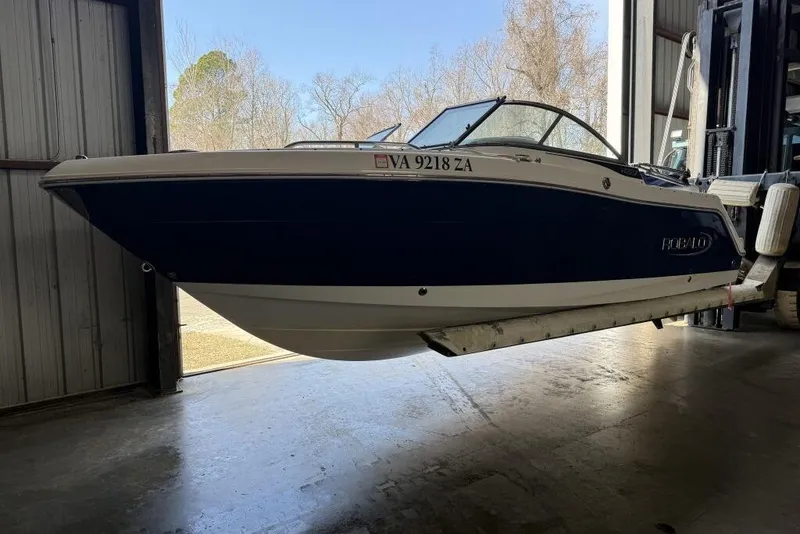 The Image of 2020 Robalo R227 Dual Console boat in storage, blue and white exterior. - 0
