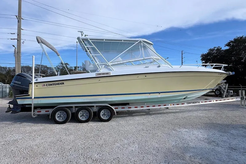The Image of 2005 Contender 35 Express Side Console boat on trailer, parked outdoors. - 0
