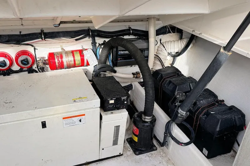 Slide: The Image of Engine compartment of a 2005 Contender 35 Express Side Console with equipment and fire extinguisher. - 18