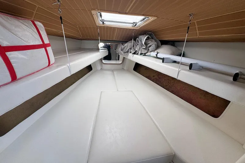 Slide: The Image of 2005 Contender 35 Express Side Console cabin interior with white seating and storage. - 21