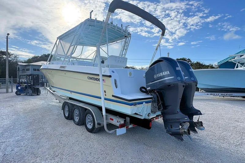 Slide: The Image of 2005 Contender 35 Express Side Console boat with dual Yamaha engines on trailer. - 3