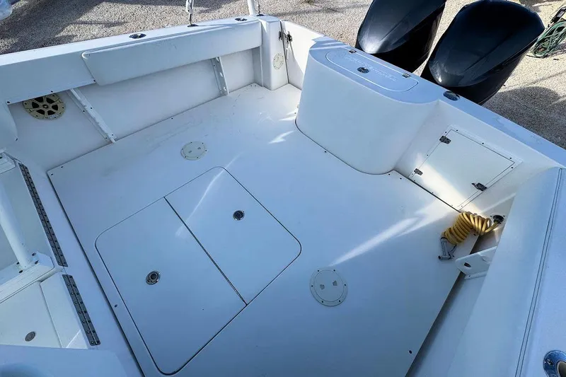 Slide: The Image of 2005 Contender 35 Express Side Console boat deck with storage compartments and dual engines. - 5