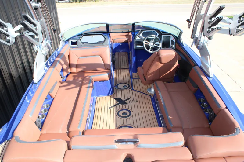 Slide: The Image of 2021 MasterCraft XStar boat interior with brown seating and sleek design. - 11