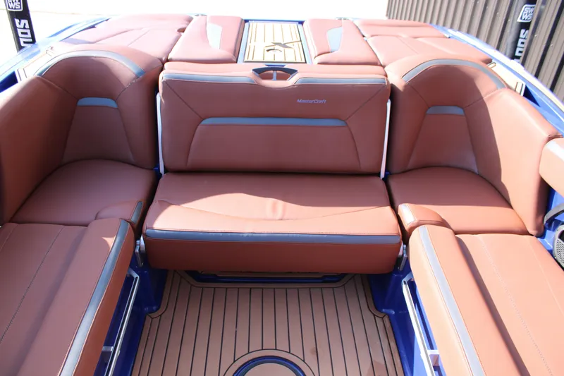 Slide: The Image of 2021 MasterCraft XStar boat interior with brown leather seating and teak flooring. - 12