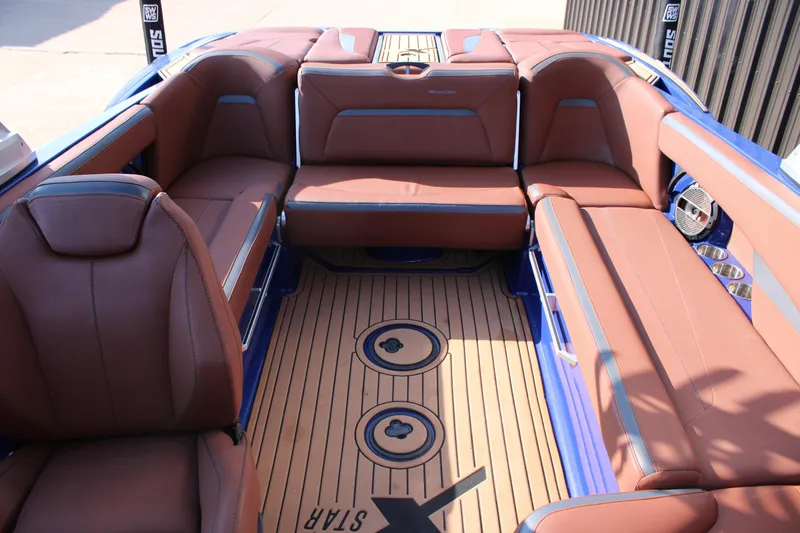 Slide: The Image of 2021 MasterCraft XStar interior with brown leather seats and teak-style flooring. - 14