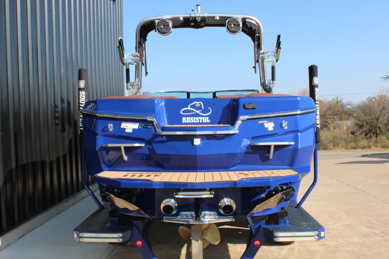 Slide: The Image of 2021 MasterCraft XStar boat, blue exterior, rear view with teak swim platform. - 15