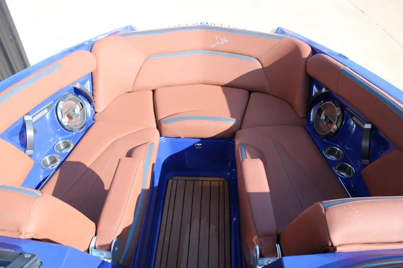 Slide: The Image of 2021 MasterCraft XStar boat interior with brown seating and blue accents. - 4