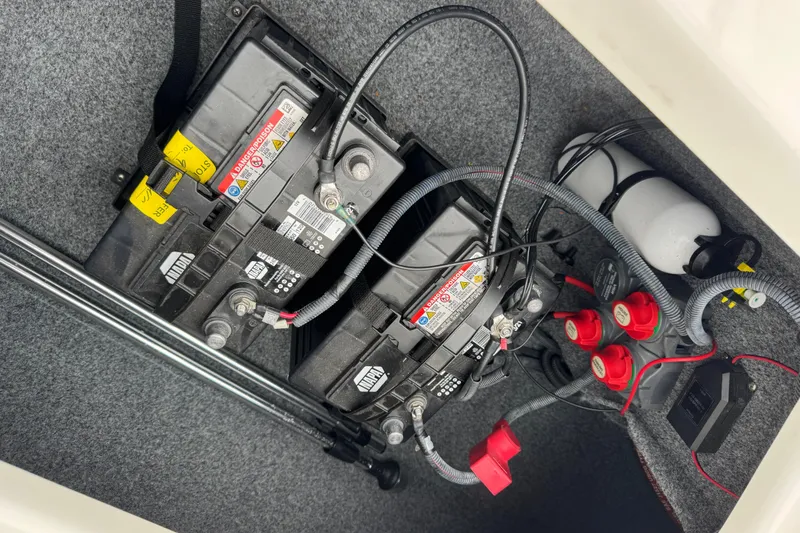 Slide: The Image of 2012 Yamaha Boats 242 Limited S battery compartment with wiring and fire extinguisher. - 24