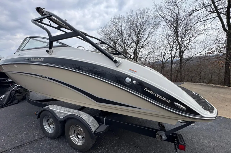 Slide: The Image of 2012 Yamaha Boats 242 Limited S on trailer, twin engine, parked outdoors. - 6