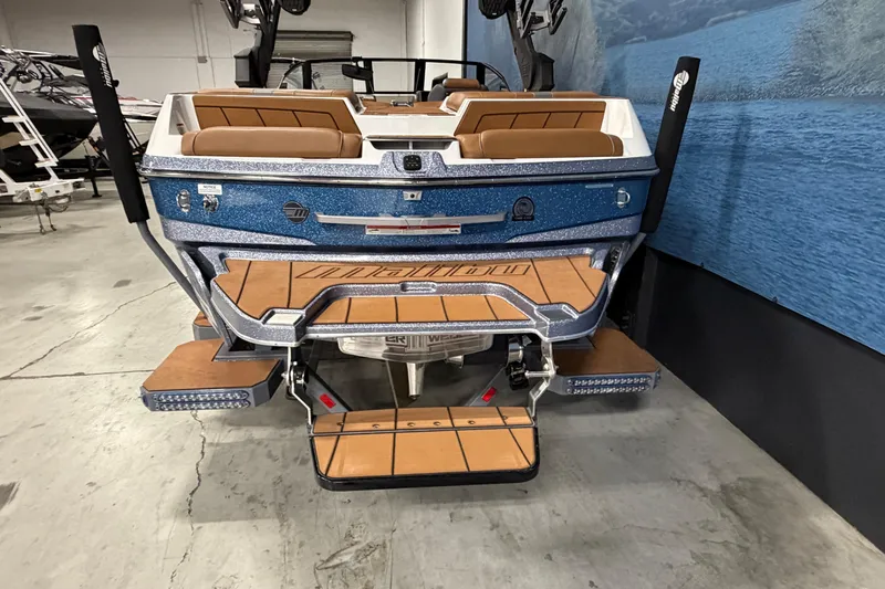 Slide: The Image of 2023 Malibu Wakesetter 23 LSV boat, rear view in showroom, featuring blue and tan design. - 4