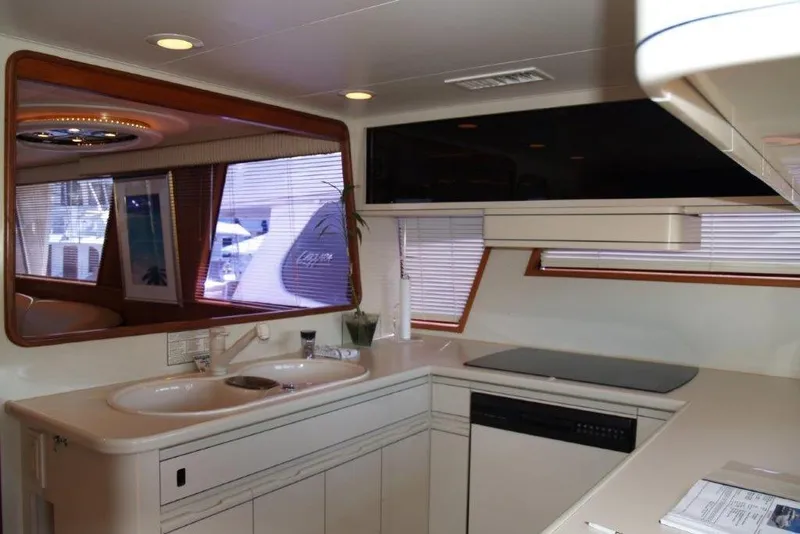 Slide: The Image of Interior of 1991 Viking 65 Cockpit yacht, featuring modern kitchen with double sink and appliances. - 11