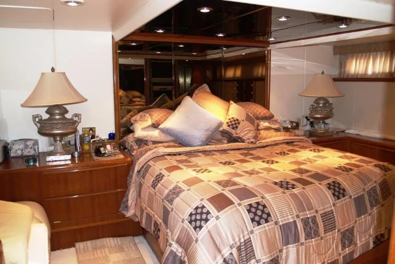 Slide: The Image of Luxurious bedroom interior on a 1991 Viking 65 Cockpit yacht, featuring elegant bedding and lamps. - 13