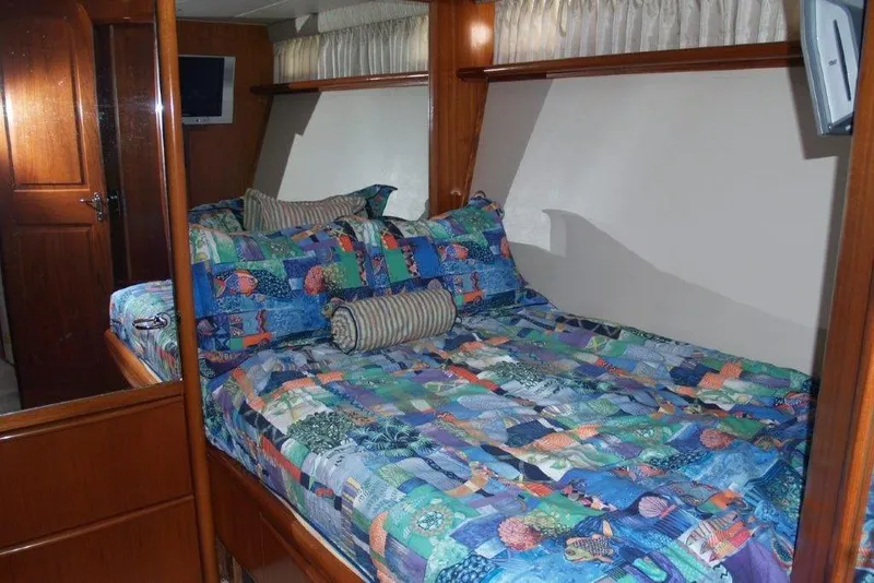 Slide: The Image of 1991 Viking 65 Cockpit bedroom with colorful bedding and wooden interior. - 17