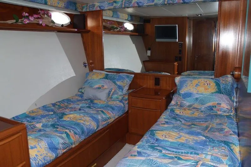 Slide: The Image of 1991 Viking 65 Cockpit yacht interior with twin beds and colorful bedding. - 19