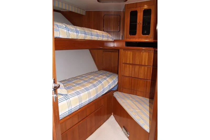 Slide: The Image of 1991 Viking 65 Cockpit interior with wooden bunk beds and storage cabinets. - 21