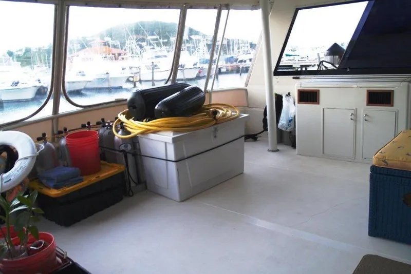 Slide: The Image of 1991 Viking 65 Cockpit interior with storage, hoses, and marina view through windows. - 24