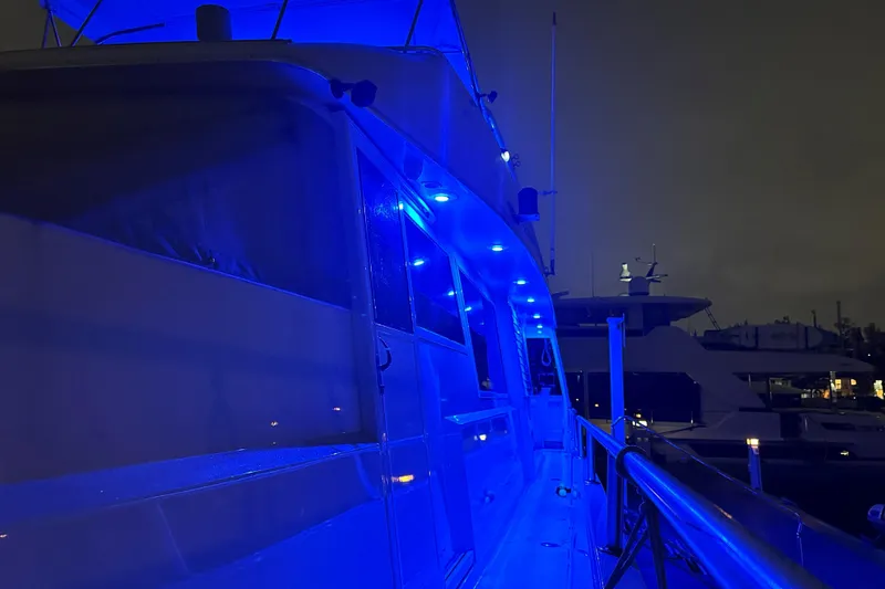 Slide: The Image of 1991 Viking 65 Cockpit yacht illuminated with blue lights at night. - 25