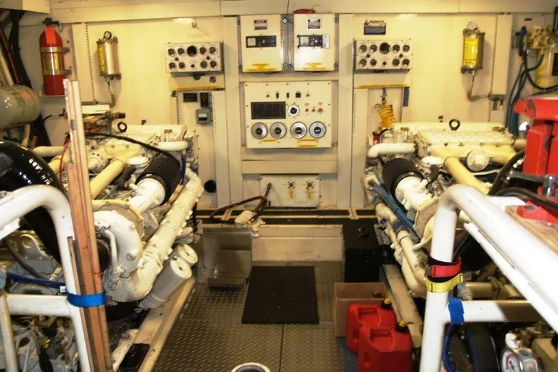 Slide: The Image of Engine room of a 1991 Viking 65 Cockpit yacht, featuring dual engines and control panels. - 27