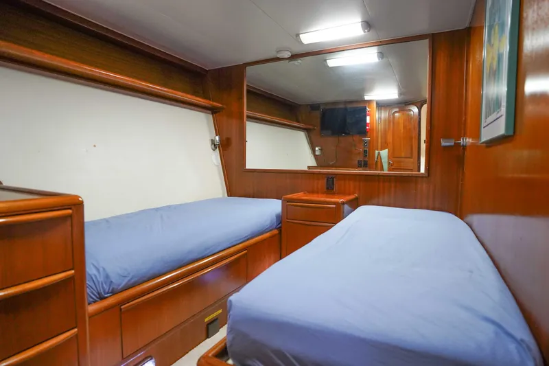 Slide: The Image of Interior of 1991 Viking 65 Cockpit yacht with twin beds and wooden furnishings. - 29