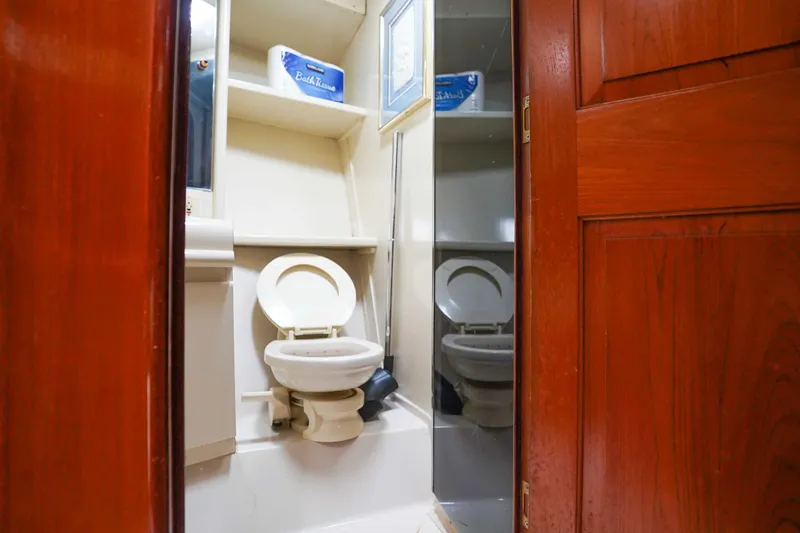 Slide: The Image of Bathroom interior of 1991 Viking 65 Cockpit yacht, featuring toilet and wooden door. - 31