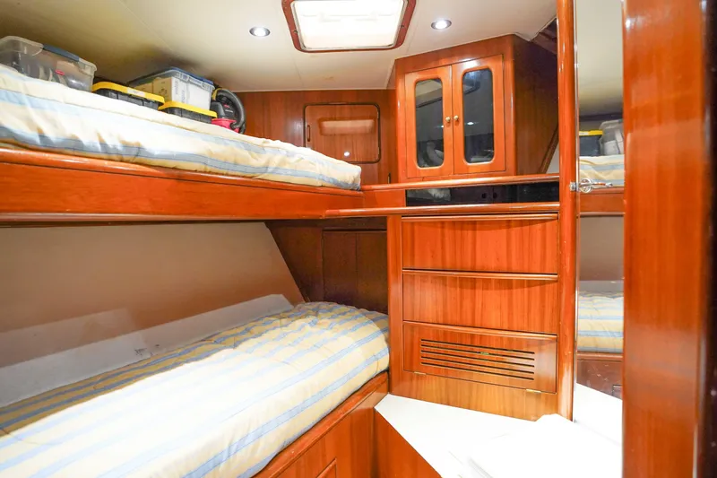 Slide: The Image of Interior of 1991 Viking 65 Cockpit yacht with wooden bunk beds and storage cabinets. - 32