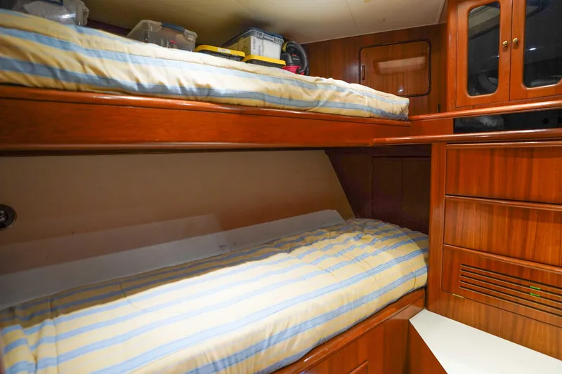 Slide: The Image of Interior of 1991 Viking 65 Cockpit yacht with wooden bunk beds and storage. - 33