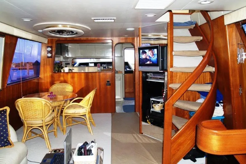 Slide: The Image of Luxurious interior of 1991 Viking 65 Cockpit yacht with wooden decor and spiral staircase. - 4