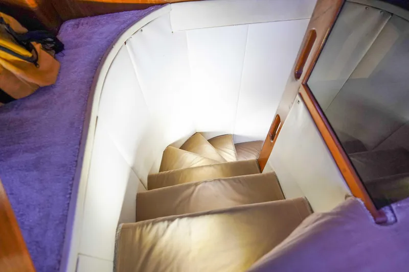 Slide: The Image of Staircase inside 1991 Viking 65 Cockpit yacht, featuring plush carpeting and wooden accents. - 40