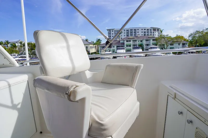 Slide: The Image of Captain's chair on 1991 Viking 65 Cockpit yacht, with marina and buildings in background. - 48