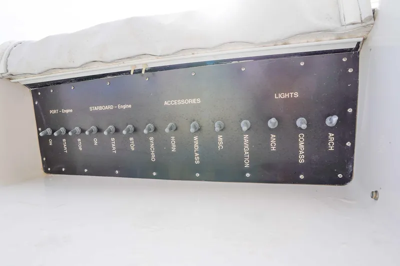 Slide: The Image of Control panel of a 1991 Viking 65 Cockpit yacht with labeled switches. - 53