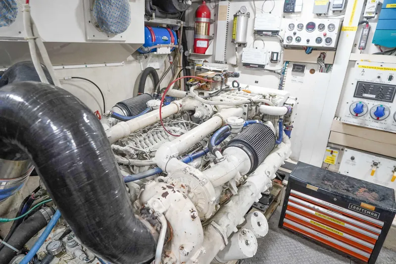 Slide: The Image of Engine room of a 1991 Viking 65 Cockpit yacht, featuring complex machinery and control panels. - 54