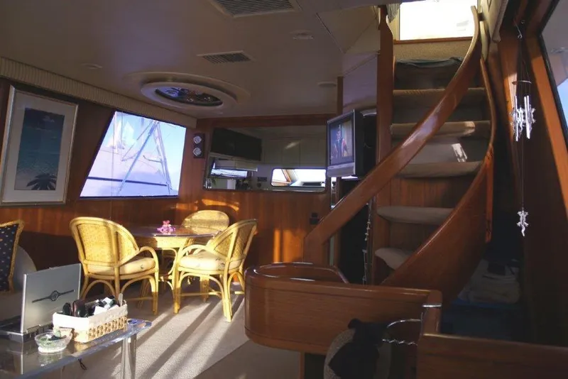 Slide: The Image of Luxurious interior of a 1991 Viking 65 Cockpit yacht with elegant seating and wooden staircase. - 8