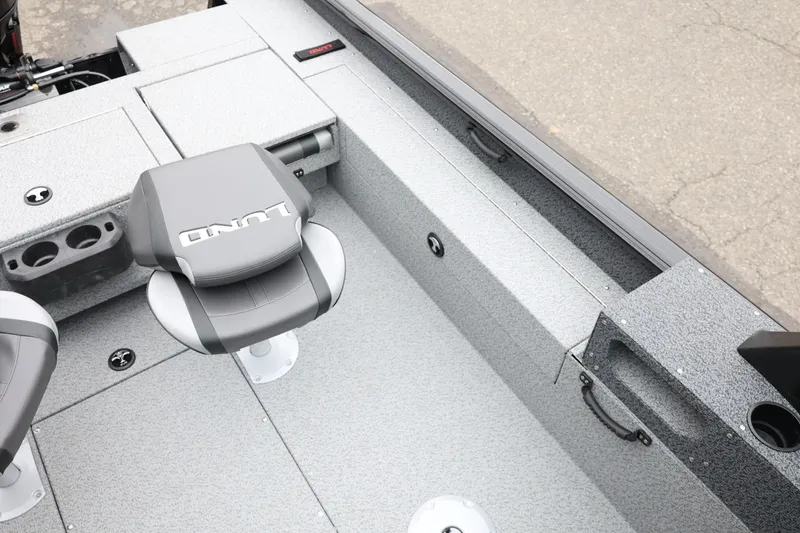 Slide: The Image of 2026 Lund 1775 Impact XS Sport boat interior with gray seating and storage compartments. - 26