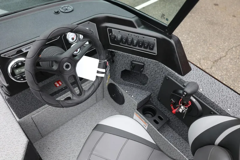 Slide: The Image of 2026 Lund 1775 Impact XS Sport boat interior with steering wheel and control panel. - 27